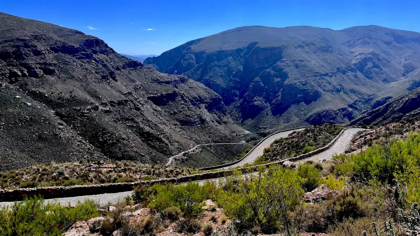Gravel switchbacks climbing the Swartberg Pass, held by dry-stone retaining walls, Western Cape, South Africa